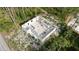 Aerial view of cinder block home under construction in sandy, partially wooded area with blue sky at 17461 Dudley Ave, Port Charlotte, FL 33954
