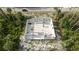 Aerial top shot of unfinished cinder block home next to a two-lane road in wooded area, surrounded by palms at 17461 Dudley Ave, Port Charlotte, FL 33954