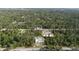 Wide aerial view shows wooded residential neighborhood with block home under construction in center at 17461 Dudley Ave, Port Charlotte, FL 33954
