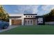 Modern home with a sleek design, wooden garage door, and well-manicured lawn at 17461 Dudley Ave, Port Charlotte, FL 33954