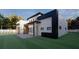A modern home with a beautiful lawn features sleek architectural details and minimalist design at 17461 Dudley Ave, Port Charlotte, FL 33954