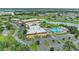 Wonderful aerial view of the community clubhouse and pool, nestled among lush landscaping and a tranquil pond at 1906 Canterbury Ln # 16, Sun City Center, FL 33573