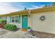 Charming home entrance with a vibrant turquoise door, well-maintained landscaping, and a welcoming 'Welcome' mat at 1906 Canterbury Ln # 16, Sun City Center, FL 33573