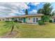 Quaint single-story home featuring lush green landscaping and a vibrant blue-green front door at 1906 Canterbury Ln # 16, Sun City Center, FL 33573