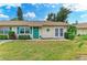 Charming single-story home featuring a vibrant green door, lush landscaping, and a welcoming front yard at 1906 Canterbury Ln # 16, Sun City Center, FL 33573