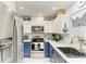Stylish kitchen with stainless steel appliances, blue and white cabinets, and white countertops at 1906 Canterbury Ln # 16, Sun City Center, FL 33573