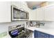 Updated kitchen with stainless steel microwave and range, white cabinets, and blue lower cabinets at 1906 Canterbury Ln # 16, Sun City Center, FL 33573