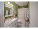 Nautical bathroom with green walls, white cabinets, granite countertop, and decorative accessories at 2016 Bonito Way, Port Charlotte, FL 33953