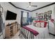 Comfortable bedroom featuring black metal bed frame, white walls with dark trim, and mounted TV at 2016 Bonito Way, Port Charlotte, FL 33953