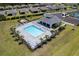 Aerial view of the community pool with sundeck and lounge chairs surrounded by manicured landscaping at 2016 Bonito Way, Port Charlotte, FL 33953