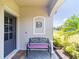 Inviting front porch with a decorative bench and charming decor detail, perfect for enjoying a quiet moment outdoors at 2016 Bonito Way, Port Charlotte, FL 33953