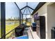 Relaxing screened patio featuring outdoor furniture and a view of a serene pond at 2016 Bonito Way, Port Charlotte, FL 33953