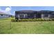 This home has a screened patio and spacious backyard with lush green grass and tidy shrubbery at 2016 Bonito Way, Port Charlotte, FL 33953