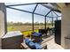 Relaxing screened-in patio with wicker furniture, an outdoor grill, and beautiful natural views at 2016 Bonito Way, Port Charlotte, FL 33953