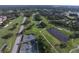 Aerial view of a lush golf course community featuring fairways, lakes, tennis courts, and beautiful homes at 2149 Muskogee Trl, Nokomis, FL 34275