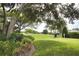 Expansive backyard with well-manicured lawn, lush trees, and vibrant vegetation bordering the golf course at 2149 Muskogee Trl, Nokomis, FL 34275