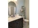 Stylish bathroom featuring a dark wood vanity with a white countertop, modern fixtures and a large mirror at 2149 Muskogee Trl, Nokomis, FL 34275