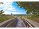Access to the sandy beach with lifeguard tower, green foliage, and clear blue skies at 2149 Muskogee Trl, Nokomis, FL 34275