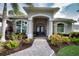 Elegant home entrance with a stone pathway, arched entryway, and well-maintained landscaping at 2149 Muskogee Trl, Nokomis, FL 34275