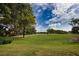 Picturesque golf course view with lush green fairways, mature trees, and a clear blue sky at 2149 Muskogee Trl, Nokomis, FL 34275