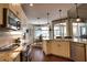 Open-concept kitchen with stainless appliances, granite counters, breakfast bar, and sliding doors to patio at 2149 Muskogee Trl, Nokomis, FL 34275
