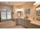 Bathroom featuring double sinks, bathtub, tile floors and white quartz counters at 2149 Muskogee Trl, Nokomis, FL 34275