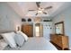 Bright main bedroom featuring a tray ceiling, ceiling fan, hardwood floors and access to en-suite at 2149 Muskogee Trl, Nokomis, FL 34275