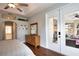 Bright main bedroom featuring a tray ceiling, ceiling fan, hardwood floors and access to sun room at 2149 Muskogee Trl, Nokomis, FL 34275