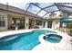 A lagoon-style pool featuring a connected hot tub and a screened-in enclosure at 2149 Muskogee Trl, Nokomis, FL 34275