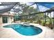 A screened pool area with a hot tub, lounge seating, and well maintained landscape at 2149 Muskogee Trl, Nokomis, FL 34275