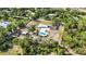 Acreage property showcasing a single-Gathering home, pool, multiple outbuildings, and ample parking in a wooded setting at 2255 61St St, Sarasota, FL 34243