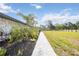 A lush backyard featuring tropical landscaping and a stone walkway with a sprawling green space at 2255 61St St, Sarasota, FL 34243