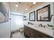 Bathroom featuring a double vanity, mirrors, wood-look floors, and a shower-tub combo at 2255 61St St, Sarasota, FL 34243
