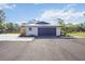 A well-lit, oversized garage showcasing its modern design and ample parking space, accented by neat landscaping at 2255 61St St, Sarasota, FL 34243