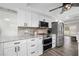 Modern kitchen with stainless steel appliances, white cabinets, tile backsplash, and neutral countertops; open concept to dining at 2255 61St St, Sarasota, FL 34243
