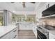 Updated kitchen features white cabinetry, stainless steel appliances, farm sink, modern fixtures and ample natural light at 2255 61St St, Sarasota, FL 34243