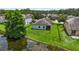 Lush backyard with a pond view, lush green lawn, and screened in porch at 2334 50Th Street E Cir, Palmetto, FL 34221