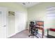 Bedroom showcasing an office setup with a computer on a wooden desk and a double door closet at 2334 50Th Street E Cir, Palmetto, FL 34221
