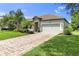 Charming home featuring a brick driveway, manicured lawn and stone facade, creating inviting curb appeal at 2334 50Th Street E Cir, Palmetto, FL 34221