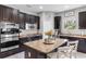 Modern kitchen with a central island, dark wood cabinetry, granite countertops, and stainless steel appliances at 2334 50Th Street E Cir, Palmetto, FL 34221