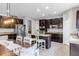 Spacious kitchen with a central island, dark wood cabinetry, granite countertops, and stainless steel appliances at 2334 50Th Street E Cir, Palmetto, FL 34221