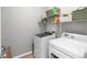 Functional laundry room with modern washer and dryer, shelving, and ample storage space at 2334 50Th Street E Cir, Palmetto, FL 34221