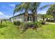 Lush side yard featuring manicured landscaping, beautiful palm trees, and a rod iron fence around the home at 2334 50Th Street E Cir, Palmetto, FL 34221
