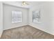 Bedroom featuring neutral carpet, two windows, and a ceiling fan at 262 Cape Harbour Loop # 101, Bradenton, FL 34212