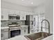 Modern kitchen featuring stainless steel appliances, light countertops, and sleek gray and white cabinets at 262 Cape Harbour Loop # 101, Bradenton, FL 34212