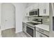 Modern kitchen featuring stainless steel appliances, light countertops, and sleek gray and white cabinets at 262 Cape Harbour Loop # 101, Bradenton, FL 34212