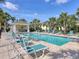 A serene community pool with lounge chairs, mature palm trees, and a gazebo at 262 Cape Harbour Loop # 101, Bradenton, FL 34212