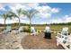 Beautifully landscaped backyard with lounge chairs, a fire pit, and lush greenery, perfect for outdoor relaxation at 26687 Raphis Royale Blvd, Englewood, FL 34223