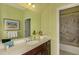 Well-lit bathroom features patterned wallpaper, a dark wood vanity and marble tile shower at 26687 Raphis Royale Blvd, Englewood, FL 34223