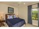 Comfortable bedroom features a ceiling fan and a window overlooking outdoor landscaping at 26687 Raphis Royale Blvd, Englewood, FL 34223